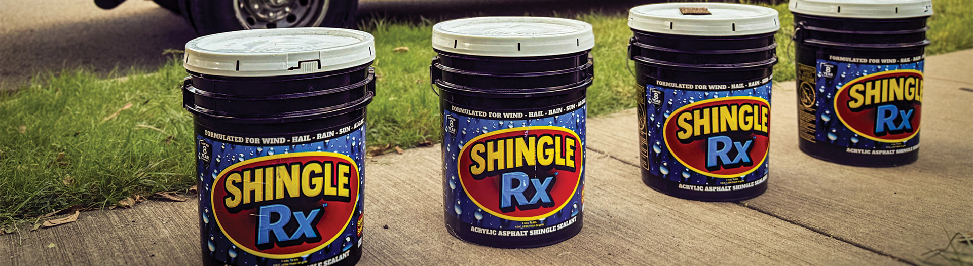 Shingle RX branded service truck with four acrylic asphalt shingle sealant buckets lined up on Florida job site